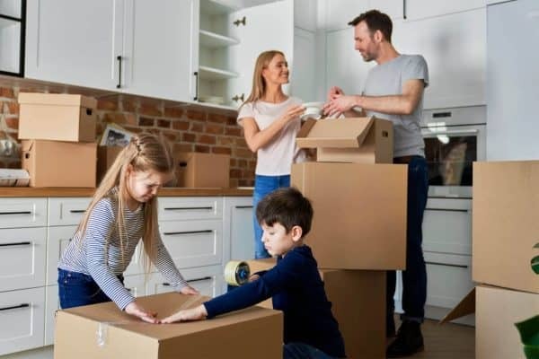 Woman smiling while preparing moving boxes in a home