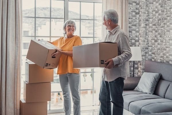 Older couple moving boxes in their home