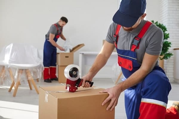 Movers packing boxes inside a home